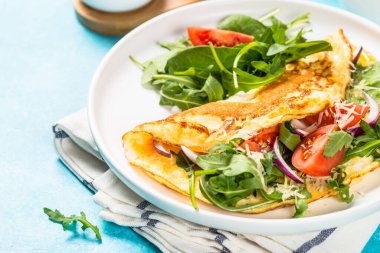 Beyaz tabakta yeşil yapraklı omlet..