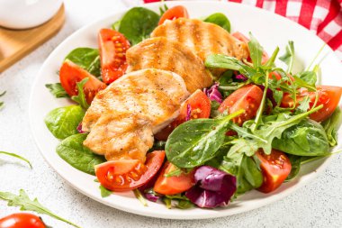 Kızarmış tavuklu salata, yeşil yapraklar ve sebzeler..