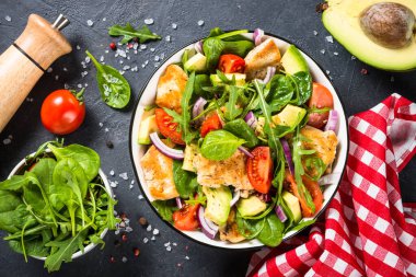 Kızarmış tavuklu salata, yeşil yapraklar ve sebzeler..