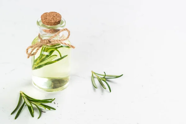 Rosemary essential oil in the bottle on white. — Stock Photo, Image