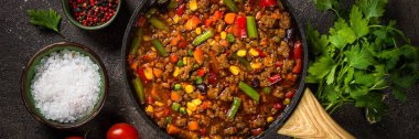 Koyu taş masada tavada Chili con carne.