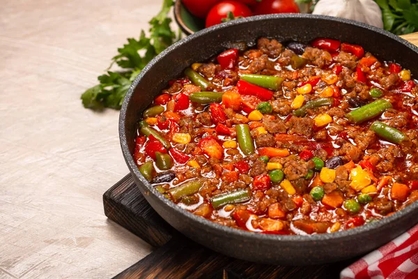 Chili con carne dalam wajan di meja batu cahaya. — Stok Foto