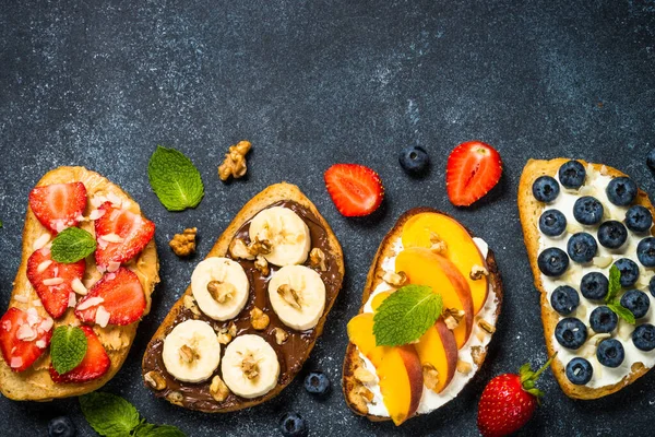 Sweet toast assortment with fresh fruit and berries on black. — Stock Photo, Image
