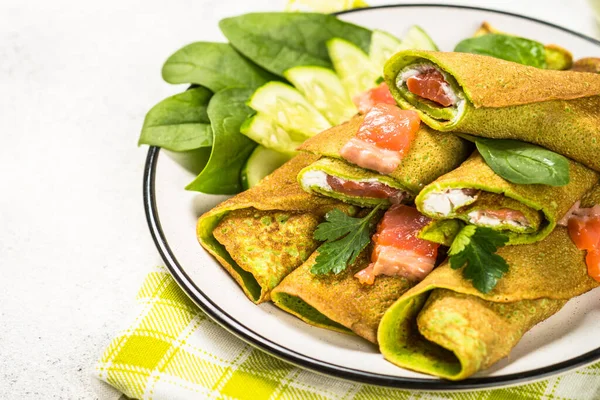 Gröna pannkakor från spenat inslagna med lax och färskost. — Stockfoto