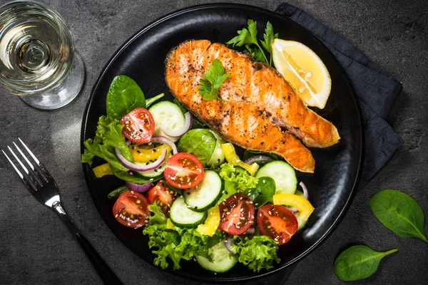 Filete de salmón a la parrilla con verduras en negro . — Foto de Stock