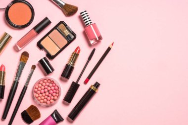 Pembe arka planda profesyonel makyaj malzemeleri.