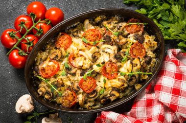 Sebzeli fırında et, siyah masanın üstünde üst görünüm..