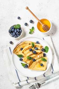 Beyaz masada yaban mersinli krep.