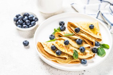 Beyaz masada yaban mersinli krep.