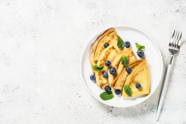 Crepes con arándanos en la mesa blanca. —  Fotos de Stock