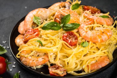 Siyah masadaki karidesli makarna..