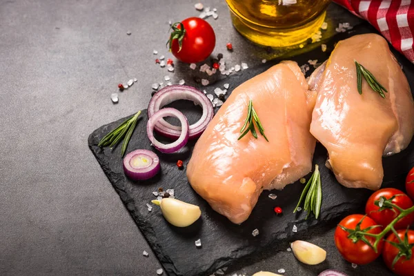 Kippenfilet met specerijen aan zwarte tafel. — Stockfoto