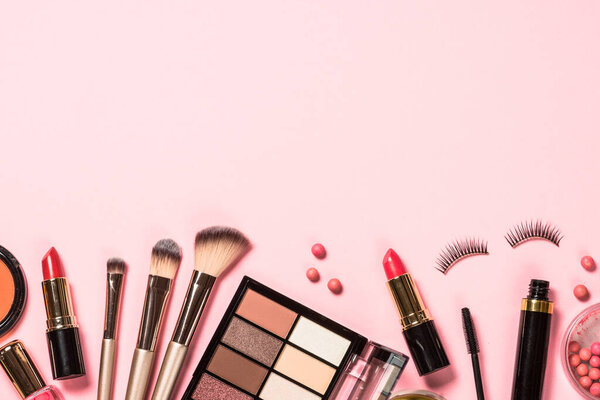 Makeup professional cosmetics on pink background.