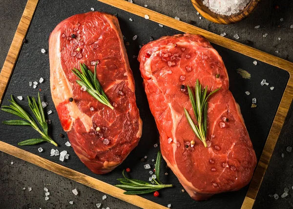 Fresh beef steak on black table. — Stock Photo, Image