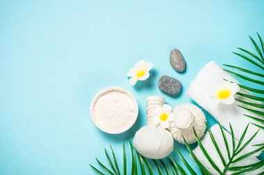 Mavi arka planda spa bitkisel sıkıştırma topları.