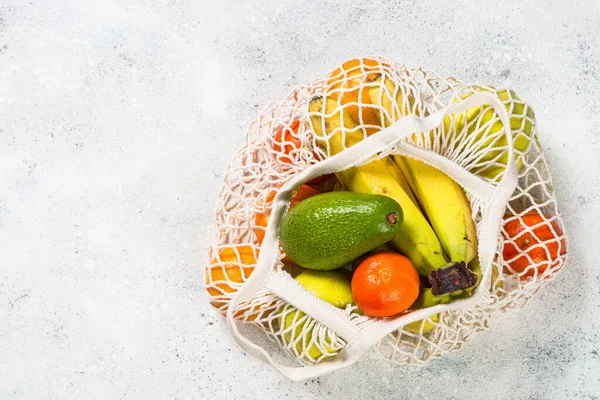 Netztasche mit Früchten auf weißem Hintergrund. — Stockfoto
