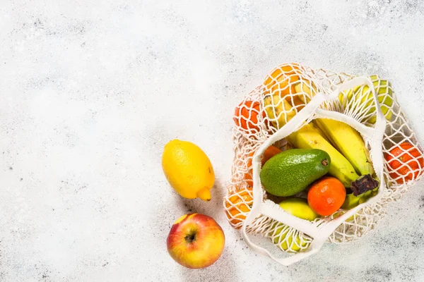 Netztasche mit Früchten auf weißem Hintergrund. — Stockfoto