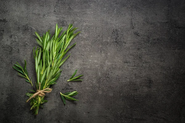 Rosemary sprig na czarnym stole kuchennym. — Zdjęcie stockowe