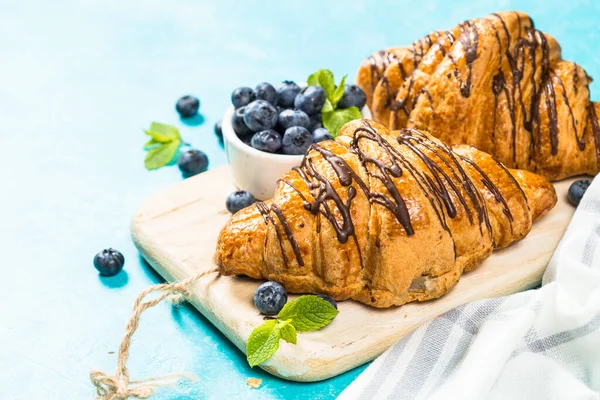 Croissant con bacche fresche su azzurro . — Foto Stock