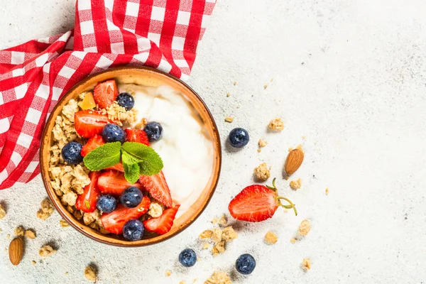 Greek yogurt granola with fresh berries on white stone table. — Stock Photo, Image