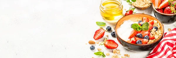 Görög joghurt granola friss bogyókkal a fehér kő asztalon. — Stock Fotó