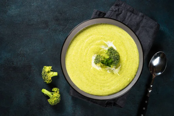 Broccoli cream soup in the bowl on dark table. — Stock Photo, Image