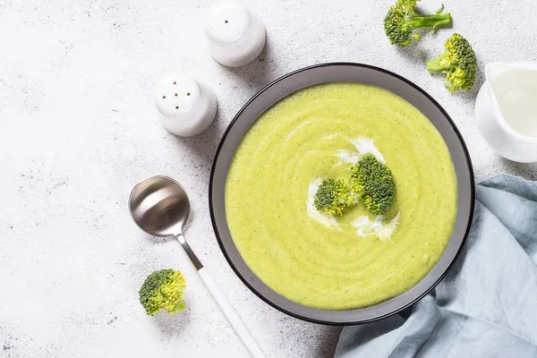 Broccoli cream soup in the bowl on white table. — Stock Image Broccoli cream soup in the bowl on white table. Stock Picture