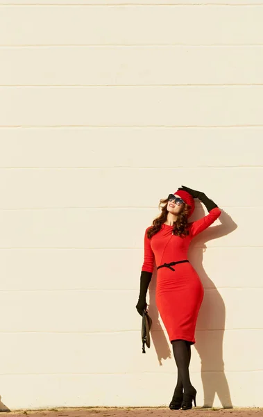 Kvinna i röd klänning om väggen. med kopia utrymme — Stockfoto