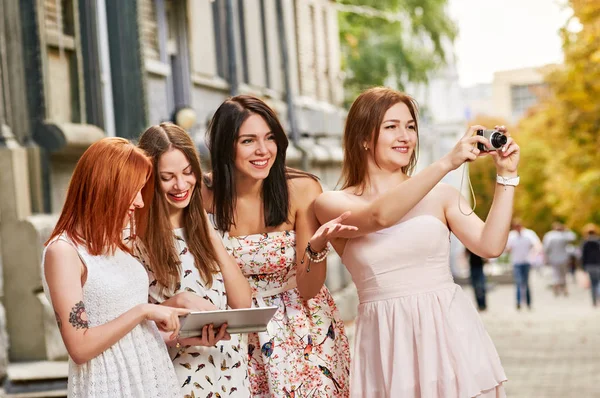 Quatre filles toursits regarder dans tablette pc et tir — Photo