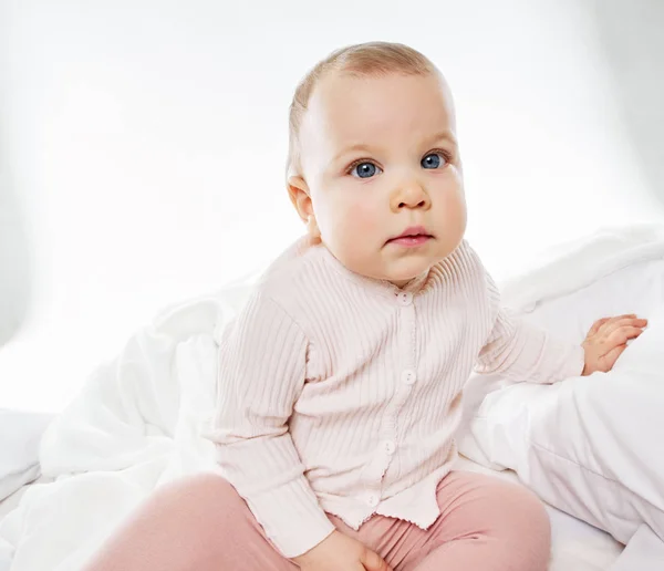 Baby meisje portret op witte bed — Stockfoto