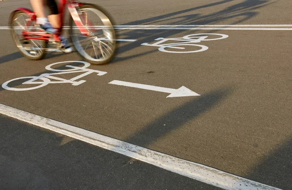 Велосипедный дорожный знак и часть велосипедного всадника — стоковое фото