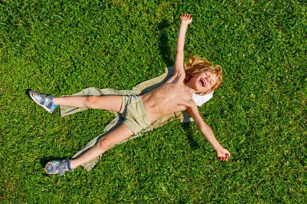 Niño acostado en la hierba — Foto de Stock