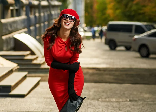 Sorrindo menina da moda em vestido vermelho na rua — Fotografia de Stock