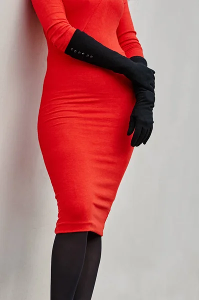 En del av kvinna i röd klänning och handskar om väggen — Stockfoto