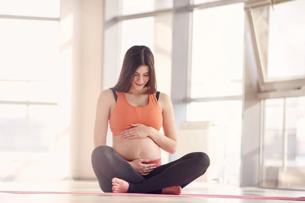 Fitness Mujer embarazada sentada en el gimnasio —  Fotos de Stock