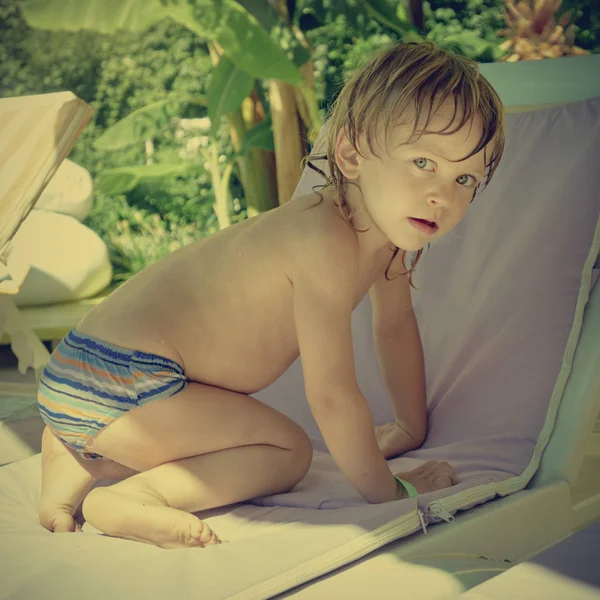 Kleine jongen op chaise-longue — Stockfoto