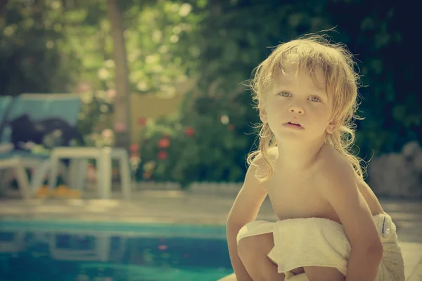 Niño sentado cerca de la piscina —  Fotos de Stock