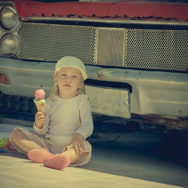 Eski arabanın yanındaki çocuk.