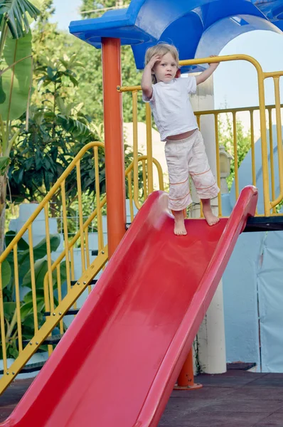 Garçon sur toboggan terrain de jeu — Photo