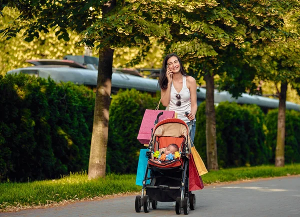 Shopping Femme Avec Bebe Chariot En Utilisant Un Telephone Portable Message Heureux Stock Photo Shopping Femme Avec Bebe Chariot En Utilisant Un Telephone Portable Message Heureux Stock Photo