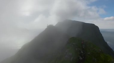 Günbatımı bulutları üzerinde Norveç dağı. En iyi bakış açısı. Bulutlardaki İHA 'dan hava görüntüsü. Helikopter harika bir uçurum manzarası çekti.