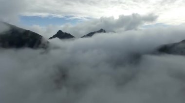 Günbatımı bulutları üzerinde Norveç dağı. En iyi bakış açısı. Bulutlardaki İHA 'dan hava görüntüsü. Helikopter harika bir uçurum manzarası çekti.