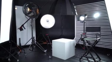 Siyah ve Beyaz Siklonama. Karanlık oda. Profesyonel ekipmanlı modern fotoğraf stüdyosu. Işık ekipmanlı boş fotoğraf stüdyosu. Yönetmen prodüksiyon koltuğuyla modern fotoğraf stüdyosunun içi..