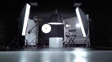 Siyah ve Beyaz Siklonama. Karanlık oda. Profesyonel ekipmanlı modern fotoğraf stüdyosu. Işık ekipmanlı boş fotoğraf stüdyosu. Yönetmen prodüksiyon koltuğuyla modern fotoğraf stüdyosunun içi..