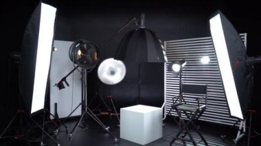 Siyah ve Beyaz Siklonama. Karanlık oda. Profesyonel ekipmanlı modern fotoğraf stüdyosu. Işık ekipmanlı boş fotoğraf stüdyosu. Yönetmen prodüksiyon koltuğuyla modern fotoğraf stüdyosunun içi..