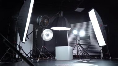 Siyah ve Beyaz Siklonama. Karanlık oda. Profesyonel ekipmanlı modern fotoğraf stüdyosu. Işık ekipmanlı boş fotoğraf stüdyosu. Yönetmen prodüksiyon koltuğuyla modern fotoğraf stüdyosunun içi..