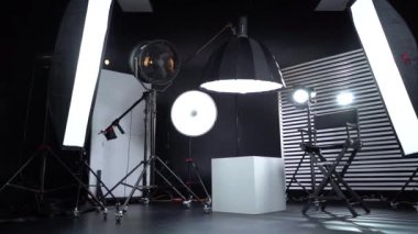 Siyah ve Beyaz Siklonama. Karanlık oda. Profesyonel ekipmanlı modern fotoğraf stüdyosu. Işık ekipmanlı boş fotoğraf stüdyosu. Yönetmen prodüksiyon koltuğuyla modern fotoğraf stüdyosunun içi..