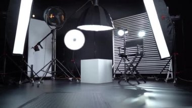 Siyah ve Beyaz Siklonama. Karanlık oda. Profesyonel ekipmanlı modern fotoğraf stüdyosu. Işık ekipmanlı boş fotoğraf stüdyosu. Yönetmen prodüksiyon koltuğuyla modern fotoğraf stüdyosunun içi..
