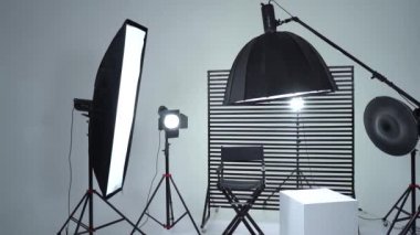 Siyah ve Beyaz Siklonama. Karanlık oda. Profesyonel ekipmanlı modern fotoğraf stüdyosu. Işık ekipmanlı boş fotoğraf stüdyosu. Yönetmen prodüksiyon koltuğuyla modern fotoğraf stüdyosunun içi..