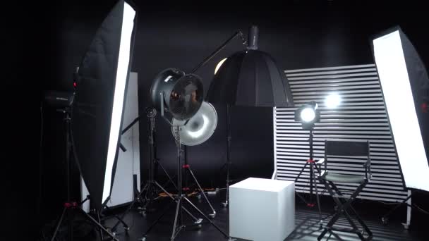 黒と白のサイクロラマ 暗い部屋だ プロ仕様のモダンな写真スタジオ 照明器具で空の写真スタジオ ディレクタープロダクションチェア付きのモダンなフォトスタジオのインテリア — ストック動画